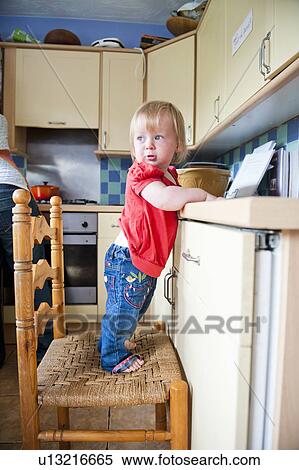Toddler girl on chair at counter View Large Photo Image Stock Photography - Toddler girl on chair at counter. Fotosearch