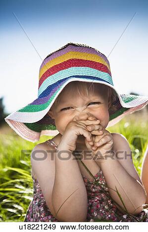 Toddler girl wearing sunhat in grass View Large Photo Image Stock Photo - Toddler girl wearing sunhat in grass. Fotosearch