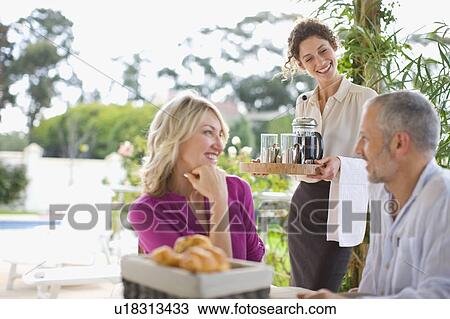 Waitress serving coffee to couple View Large Photo Image Stock Image - Waitress serving coffee to couple. Fotosearch