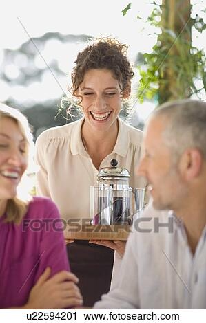 Waitress serving coffee to couple View Large Photo Image Stock Image - Waitress serving coffee to couple. Fotosearch