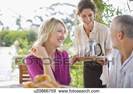 Waitress serving coffee to couple View Large Photo Image Stock Photo - Waitress serving coffee to couple. Fotosearch