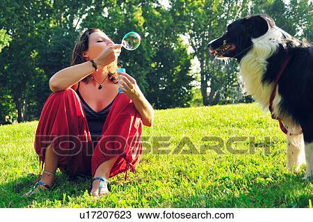 Woman blowing bubbles for dog in park View Large Photo Image Stock Image - Woman blowing bubbles for dog in park. Fotosearch