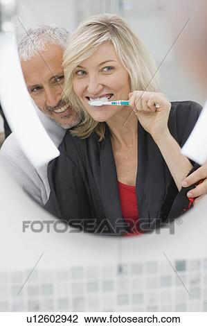 Woman brushing her teeth with husband View Large Photo Image Stock Image - Woman brushing her teeth with husband. Fotosearch