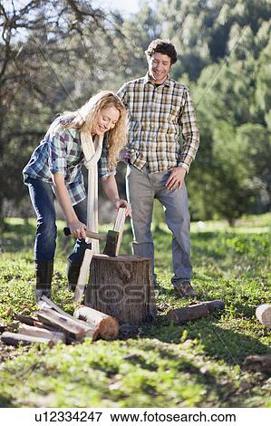 Stock Photo - Woman chopping wood outdoors. Fotosearch