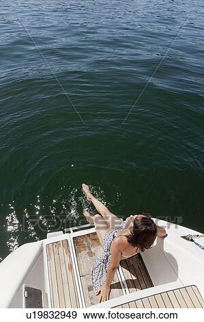 Woman dangling feet from sailboat View Large Photo Image Stock Photo - Woman dangling feet from sailboat. Fotosearch