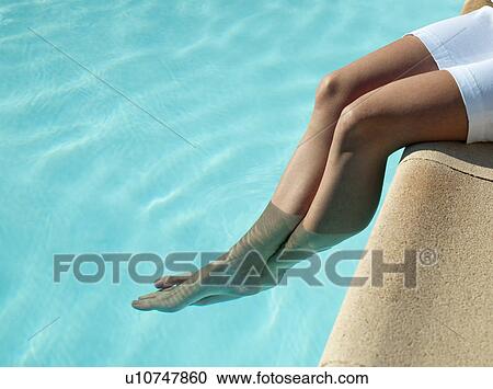 Woman dangling her feet in pool View Large Photo Image Stock Image - Woman dangling her feet in pool. Fotosearch