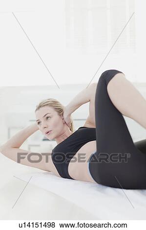 Woman doing crunches at home View Large Photo Image Stock Photo - Woman doing crunches at home. Fotosearch