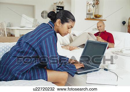 Stock Image - Woman doing homework on laptop. Fotosearch