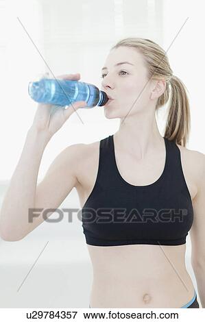 Stock Photo - Woman drinking water during workout. Fotosearch