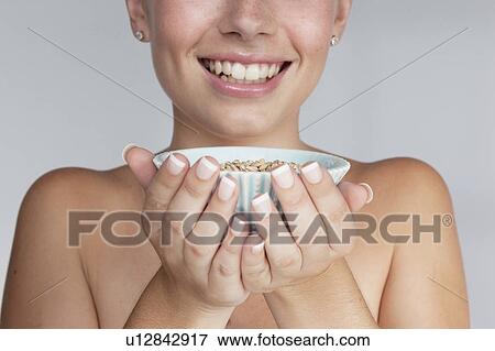 Stock Photo - Woman holding bowl of grains. Fotosearch