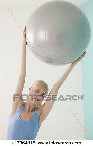 Woman holding exercise ball View Large Photo Image Stock Photo - Woman holding exercise ball. Fotosearch