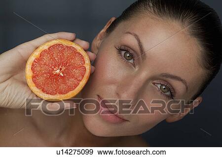 Woman holding halved grapefruit View Large Photo Image Stock Photo - Woman holding halved grapefruit. Fotosearch