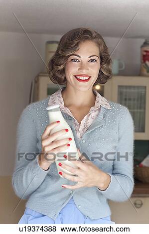 Stock Photo - Woman holding jug of milk. Fotosearch