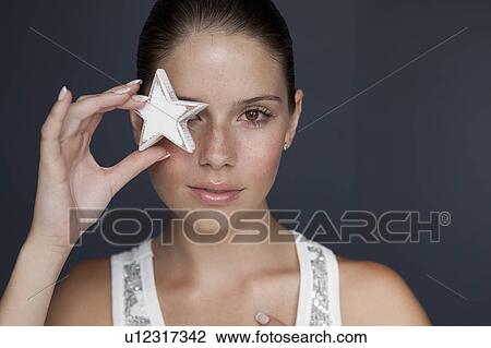 Woman holding star over her eye View Large Photo Image Stock Image - Woman holding star over her eye. Fotosearch