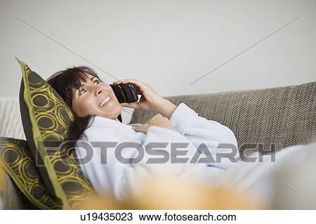 Stock Image - Woman in bathrobe talking on phone. Fotosearch