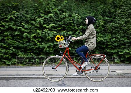 Woman in headscarf biking on cell phone View Large Photo Image Stock Image - Woman in headscarf biking on cell phone. Fotosearch