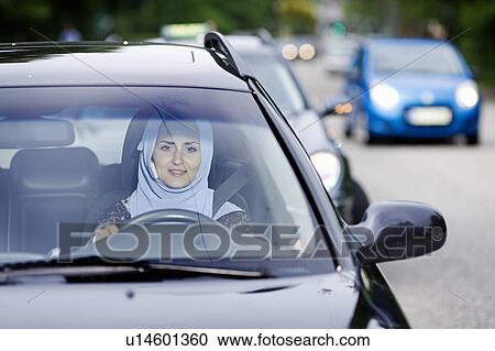 Woman in headscarf driving on cell phone View Large Photo Image Stock Image - Woman in headscarf driving on cell phone. Fotosearch