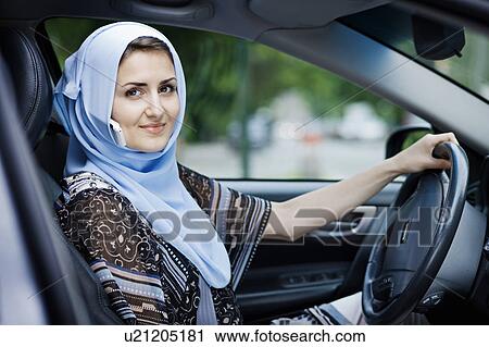 Woman in headscarf driving on cell phone View Large Photo Image Stock Image - Woman in headscarf driving on cell phone. Fotosearch