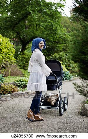 Woman in headscarf pushing stroller View Large Photo Image Stock Image - Woman in headscarf pushing stroller. Fotosearch