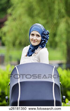 Woman in headscarf pushing stroller View Large Photo Image Stock Image - Woman in headscarf pushing stroller. Fotosearch