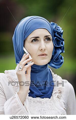 Stock Image - Woman in headscarf talking on cell phone. Fotosearch