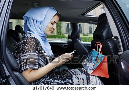 Stock Image - Woman in headscarf using cell phone. Fotosearch