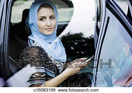 Woman in headscarf using cell phone View Large Photo Image Stock Photo - Woman in headscarf using cell phone. Fotosearch