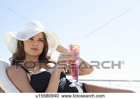 Woman in swimsuit relaxing in lawn chair View Large Photo Image Stock Image - Woman in swimsuit relaxing in lawn chair. Fotosearch
