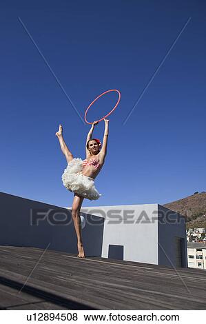 Stock Photo - Woman in tutu dancing with hula hoop. Fotosearch