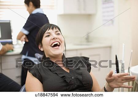 Picture - Woman laughing in dentist’s office. Fotosearch
