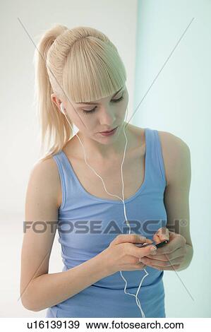 Stock Photo - Woman listening to headphones. Fotosearch