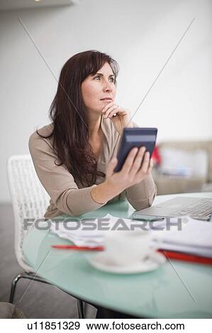 Woman paying her bills at home View Large Photo Image Stock Photo - Woman paying her bills at home. Fotosearch