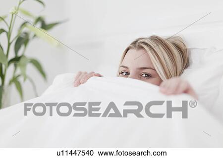 Woman peeking out from under covers View Large Photo Image Stock Image - Woman peeking out from under covers. Fotosearch