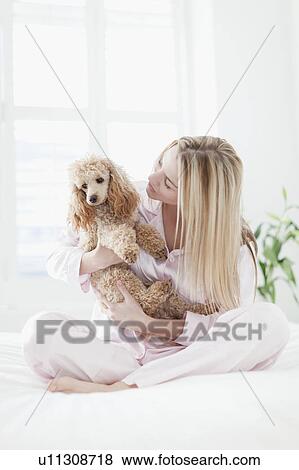 Woman playing with dog on bed View Large Photo Image Stock Photo - Woman playing with dog on bed. Fotosearch