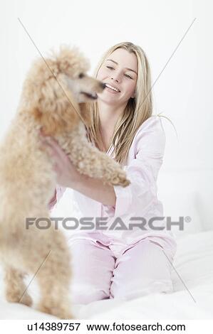 Woman playing with dog on bed View Large Photo Image Stock Photo - Woman playing with dog on bed. Fotosearch