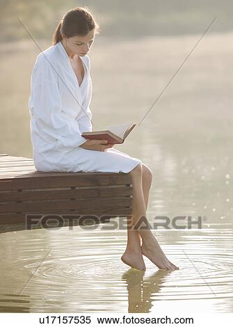 Woman reading and dangling feet in lake View Large Photo Image Stock Photography - Woman reading and dangling feet in lake. Fotosearch