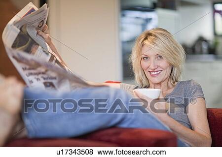 Woman reading newspaper in armchair View Large Photo Image Stock Photo - Woman reading newspaper in armchair. Fotosearch