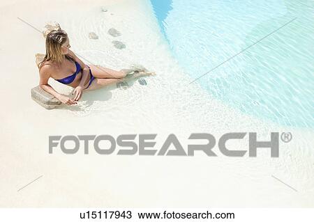 Woman relaxing by swimming pool View Large Photo Image Stock Image - Woman relaxing by swimming pool. Fotosearch