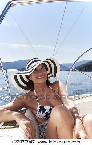 Stock Photo - Woman relaxing on sailboat. Fotosearch