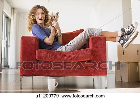 Woman relaxing with dog in armchair View Large Photo Image Stock Photo - Woman relaxing with dog in armchair. Fotosearch