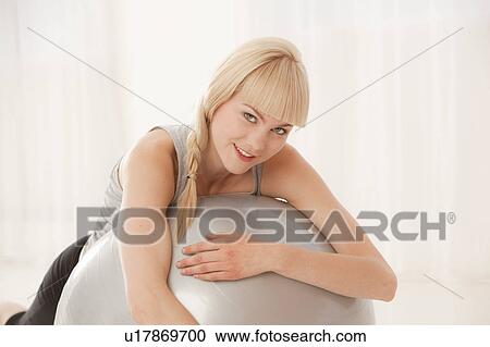 Woman resting on exercise ball View Large Photo Image Stock Image - Woman resting on exercise ball. Fotosearch