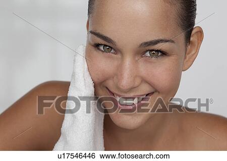 Woman scrubbing her face with cloth View Large Photo Image Stock Photograph - Woman scrubbing her face with cloth. Fotosearch