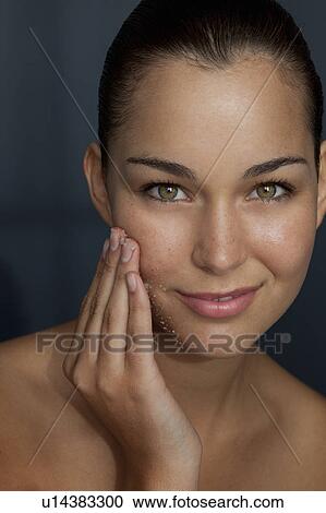 Stock Image - Woman scrubbing her face with sugar. Fotosearch