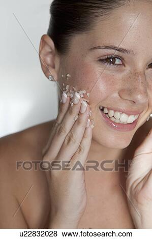 Woman scrubbing sugar on her face View Large Photo Image Stock Photo - Woman scrubbing sugar on her face. Fotosearch