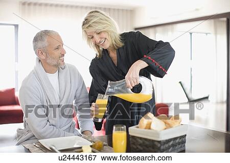 Woman serving breakfast to husband View Large Photo Image Stock Photo - Woman serving breakfast to husband. Fotosearch