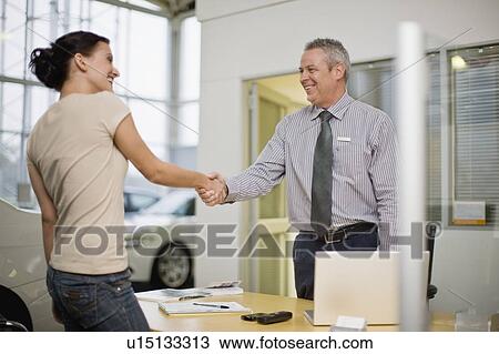 Woman shaking hands with car salesman View Large Photo Image Stock Image - Woman shaking hands with car salesman. Fotosearch