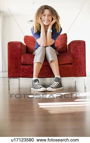Stock Image - Woman sitting in armchair. Fotosearch