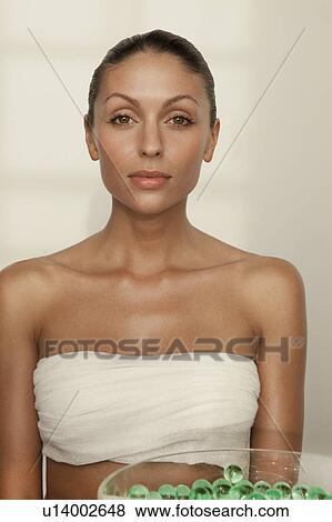 Stock Photo - Woman sitting with bowl of glass beads. Fotosearch