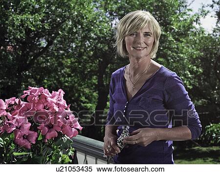 Woman smiling on balcony View Large Photo Image Stock Photography - Woman smiling on balcony. Fotosearch