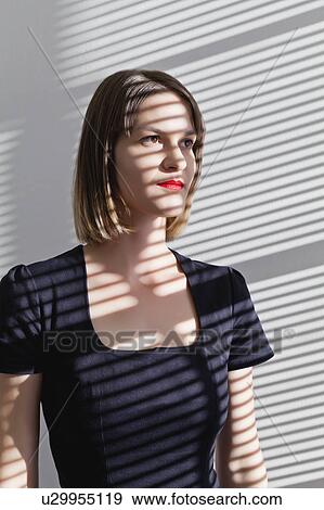 Woman standing in shadow of blinds View Large Photo Image Stock Photo - Woman standing in shadow of blinds. Fotosearch